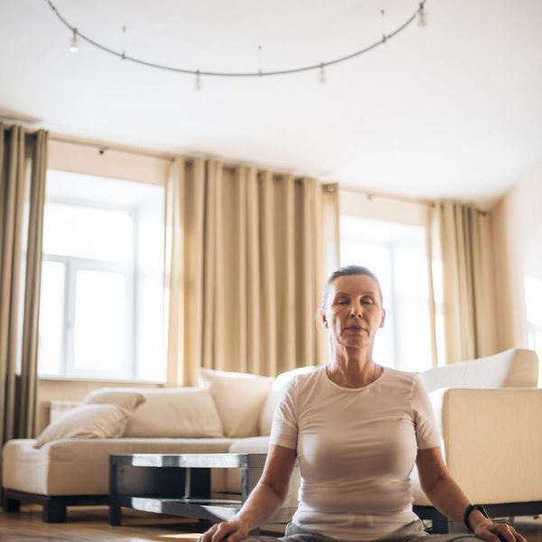 Person meditating peacefully in a bright, clean room, symbolizing inner harmony.